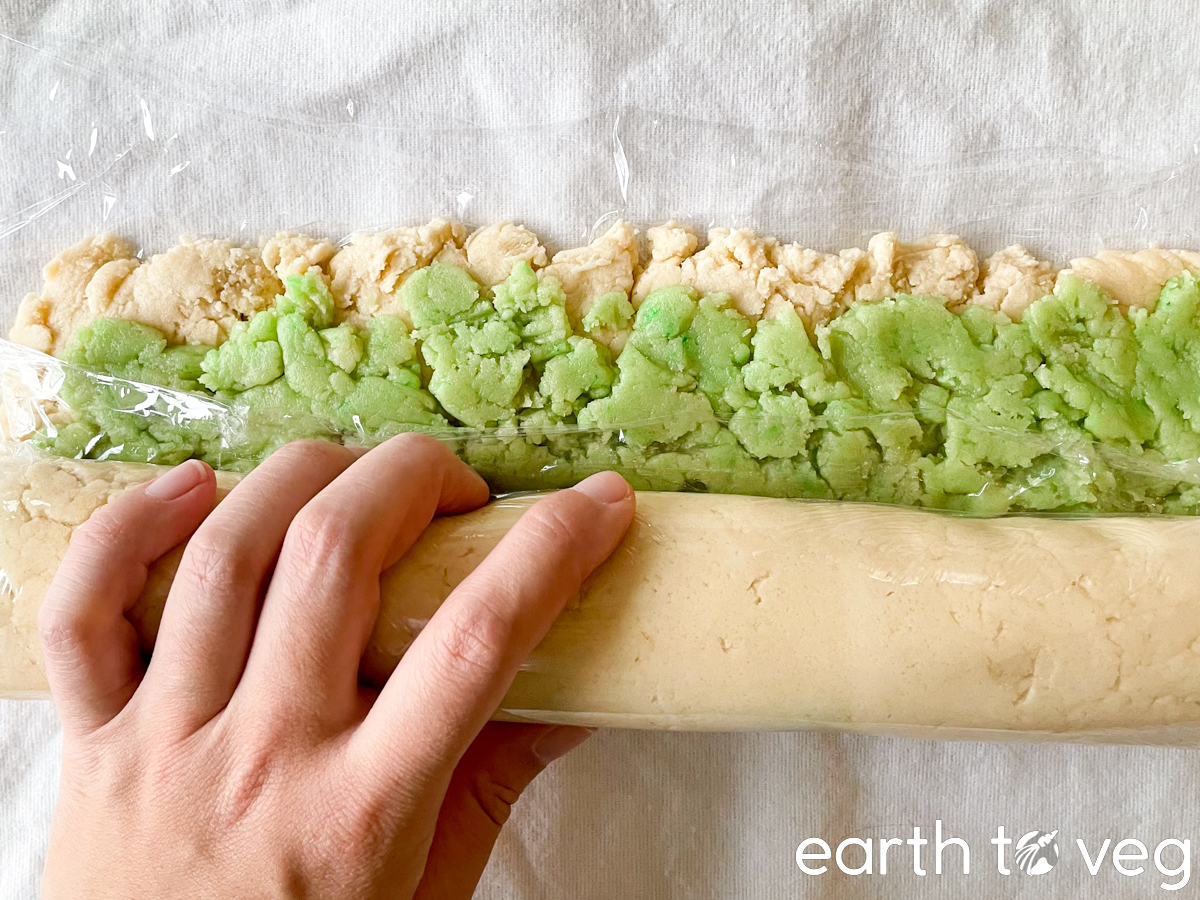 Cookie dough is rolled up into a log.