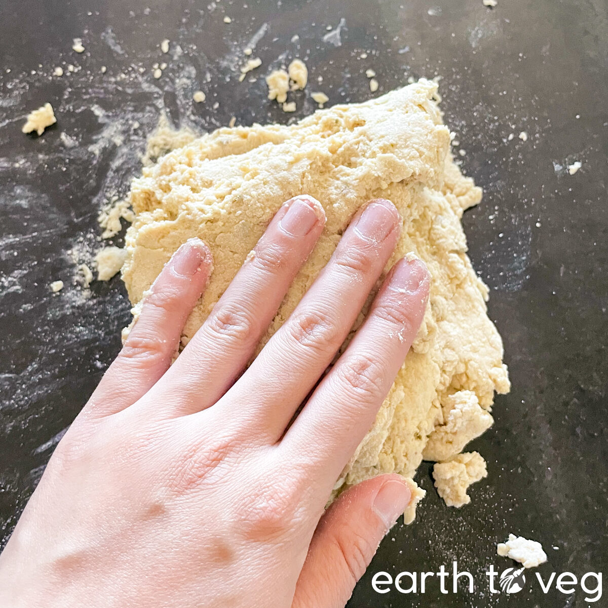 Folding soda bread dough into a square by hand.