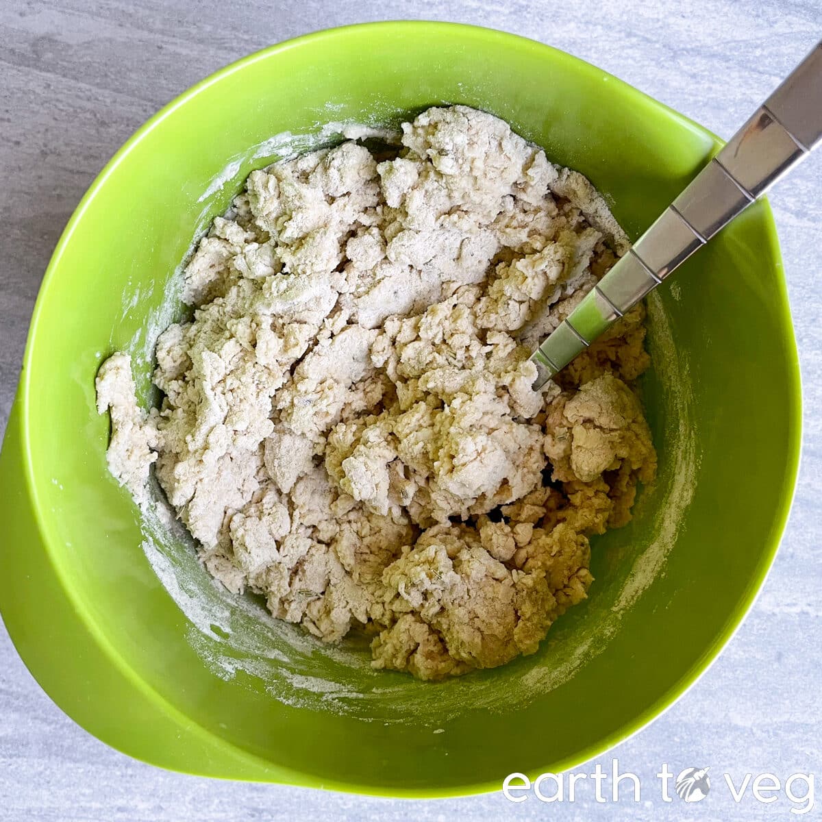 Irish soda bread dough is stirred together into a lumpy dough with a metal fork.