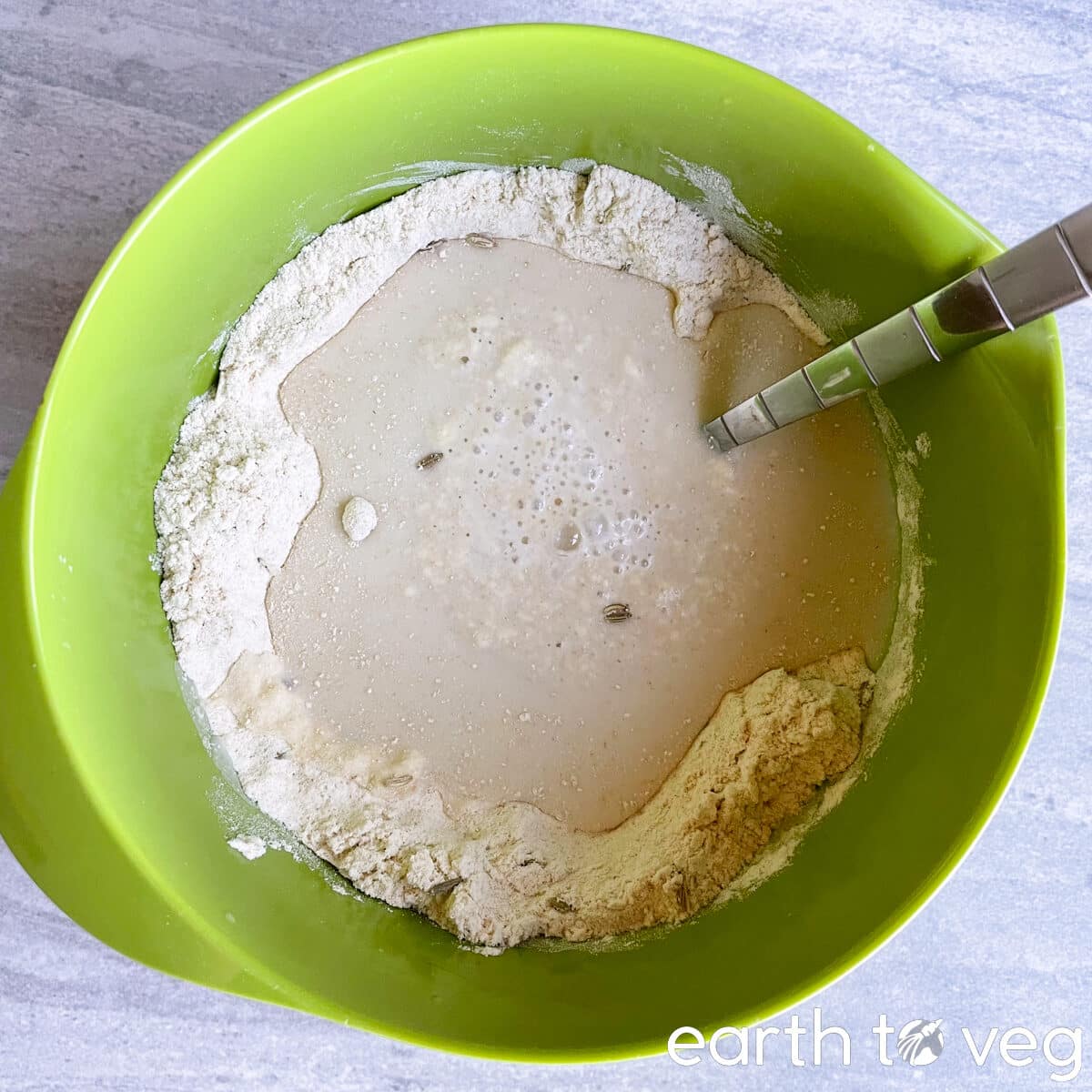 Vinegar and curdled soy milk are poured over a bowl of whole wheat flour.