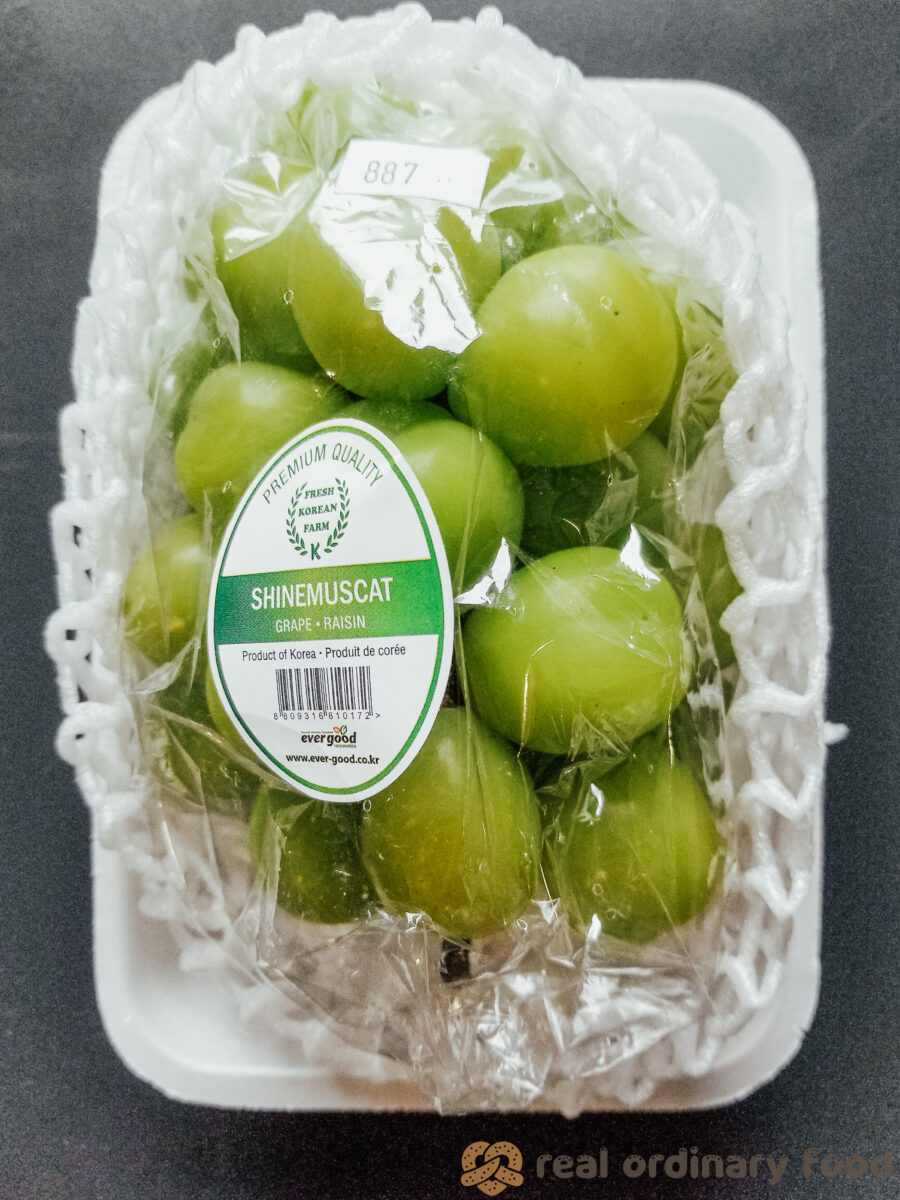 A bundle of EVERGOOD brand shine muscat grapes on a Styrofoam tray.