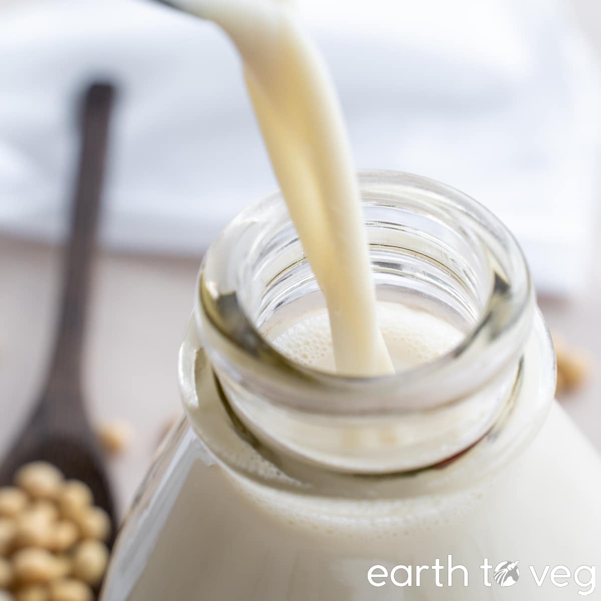 freshly cooked soy milk is poured into a glass bottle.