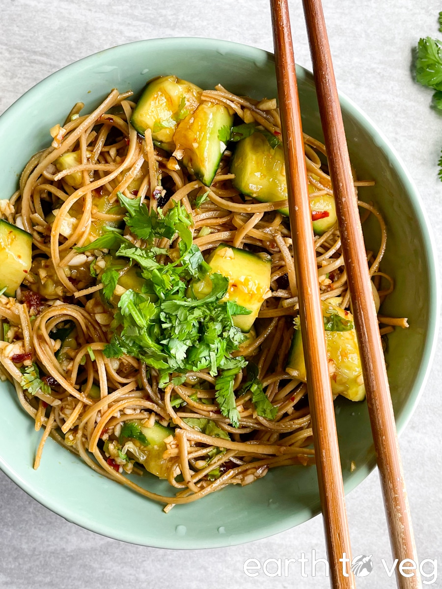 Wooden chopsticks over a bowl of cucumber zeroodle salad.