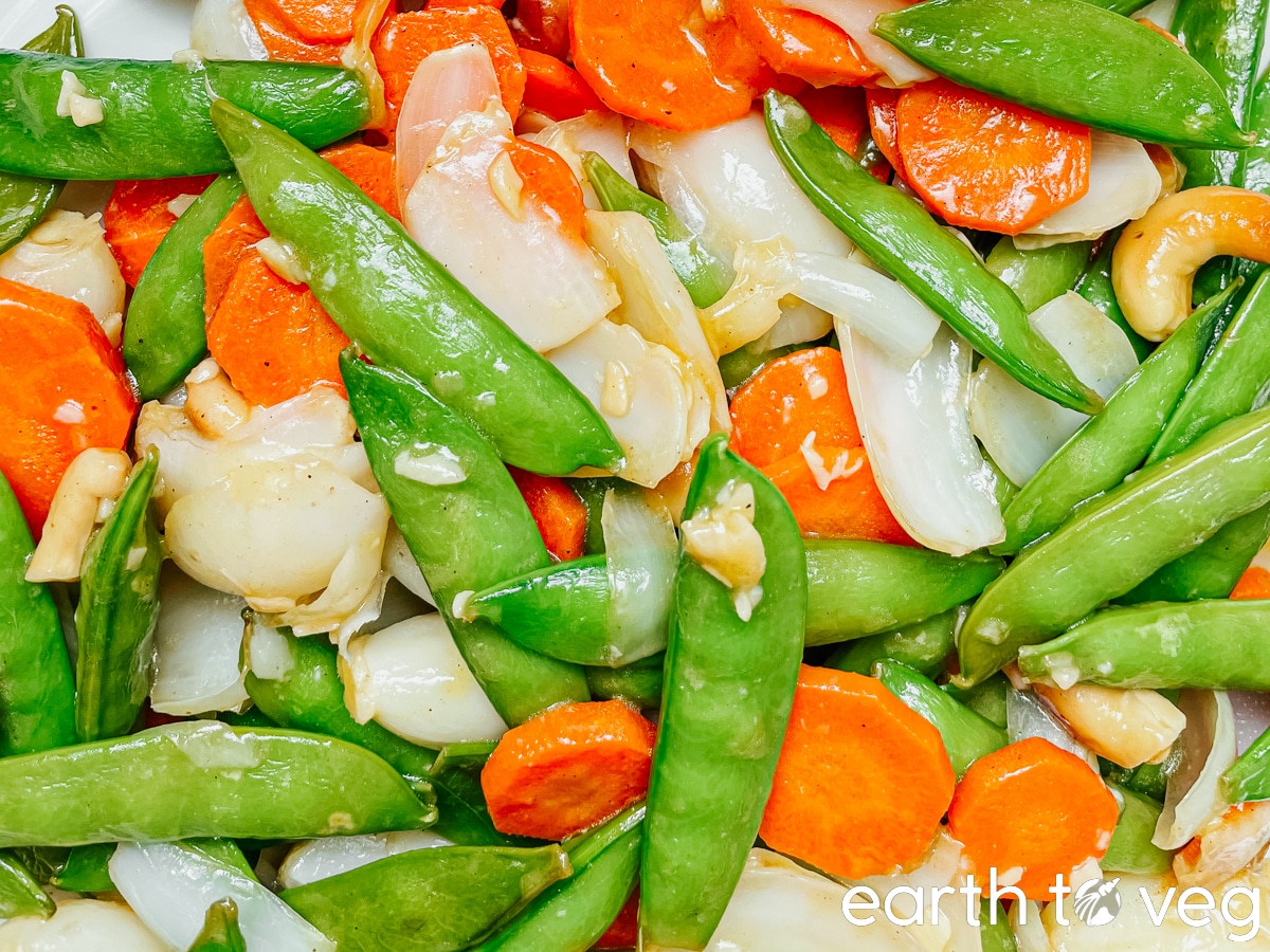 Closeup of stir fried lily bulbs with snow peas and carrots.