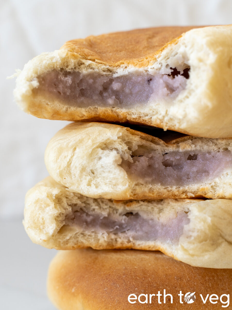 A stack of four homemade taro buns against a white backdrop.