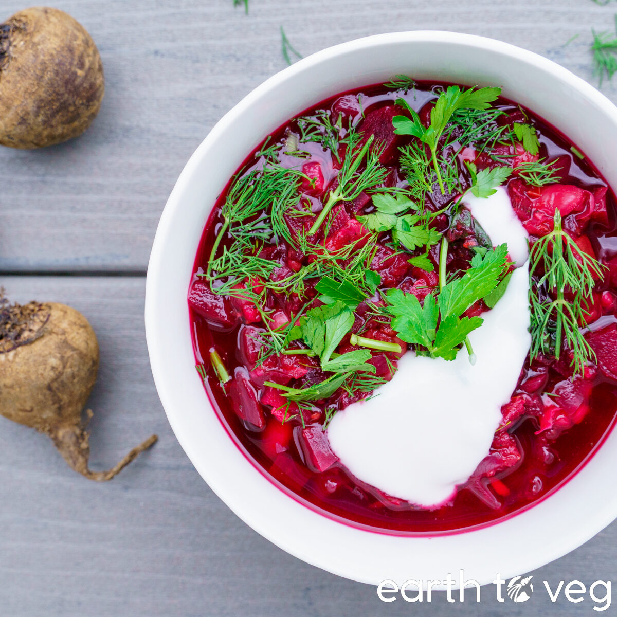 A bowl of Ukrainian Christmas borscht with dill, parsley, and dairy free sour cream.