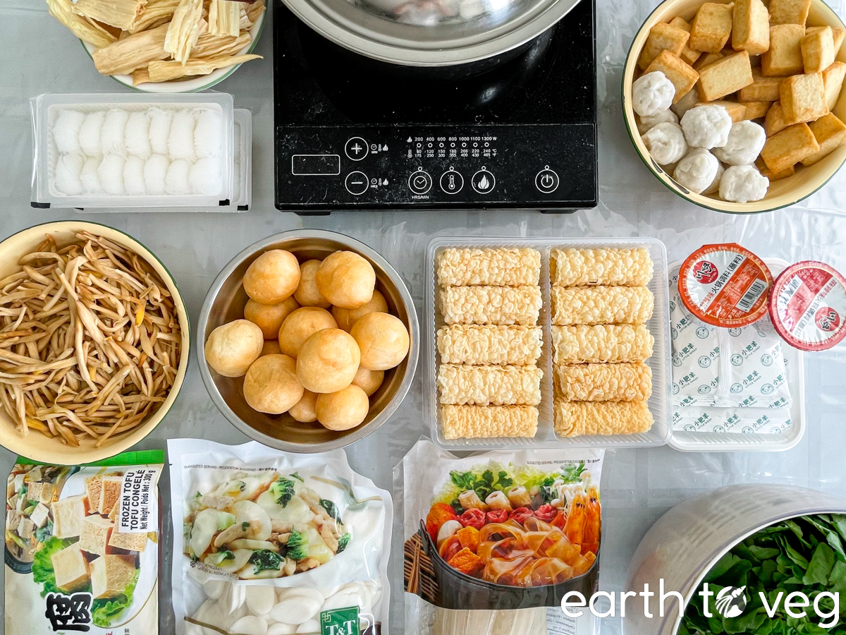 Raw vegan hot pot ingredients laid out on a dining table.