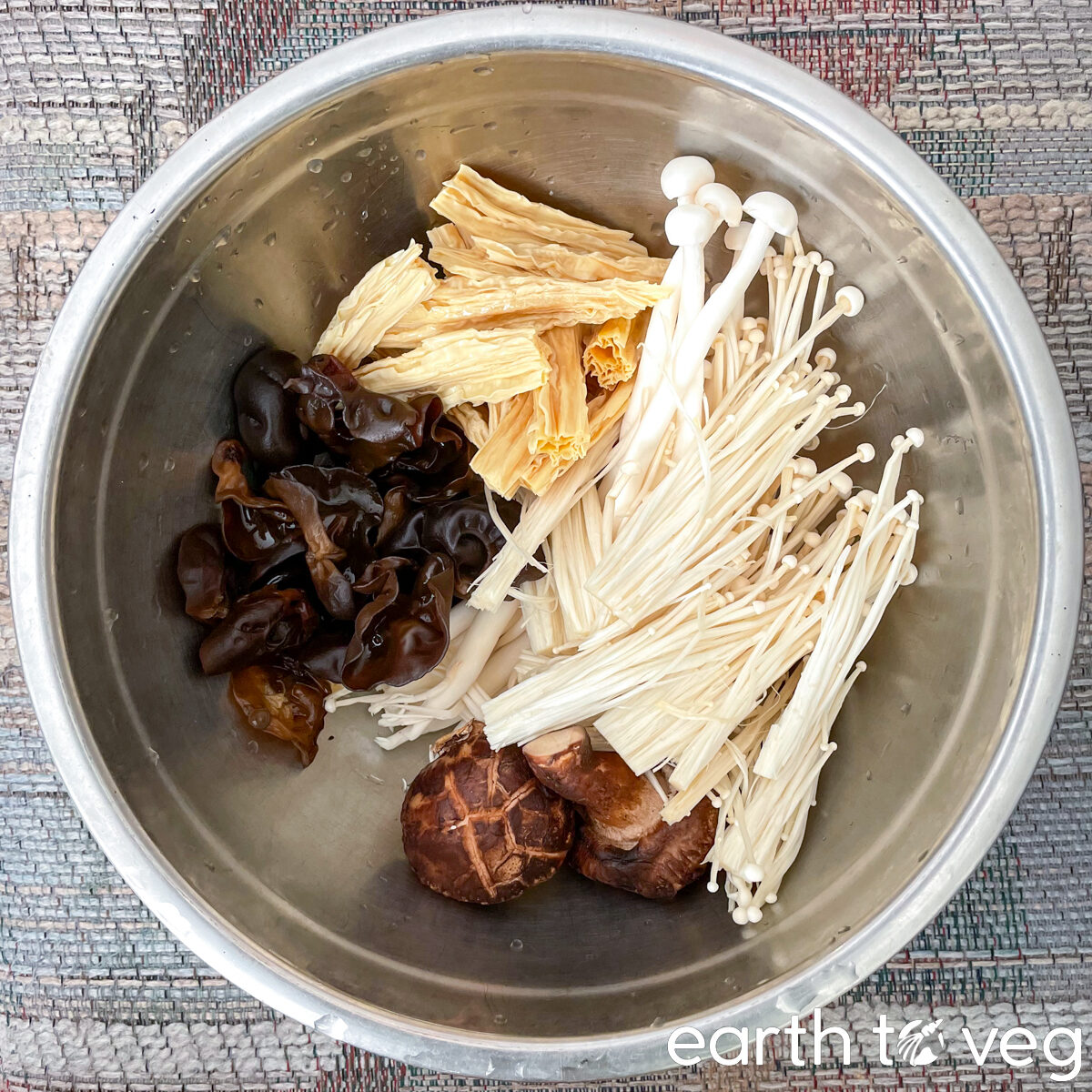 Mushrooms, fuzhu (beancurd sticks), and wood ear fungus in a stainless steel bowl.