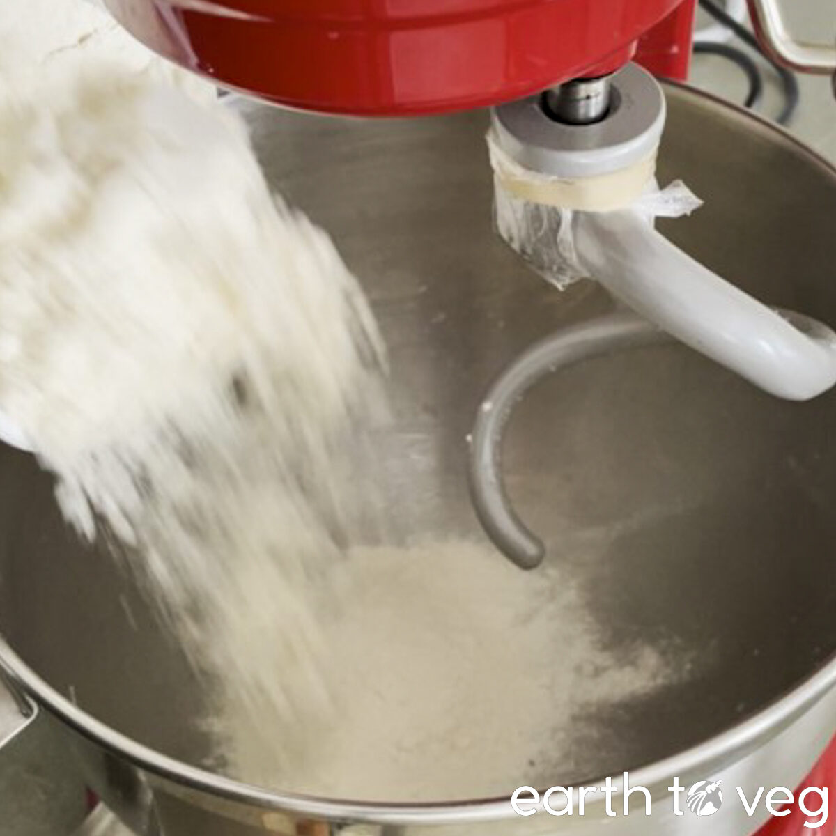 White wheat flour is added to KitchenAid stand mixer bowl.