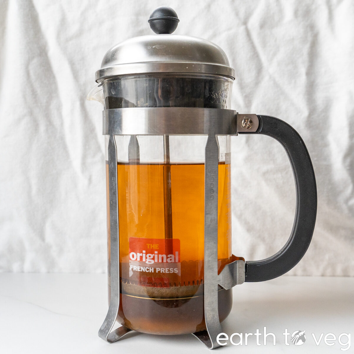 Strong black tea is steeped in a French press.