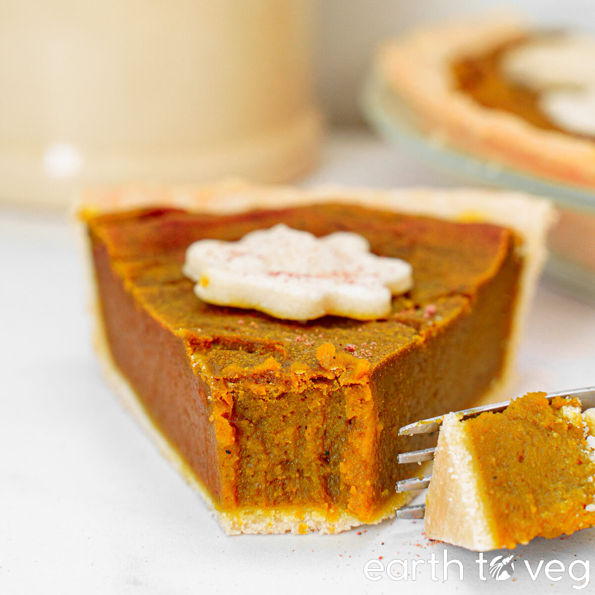 a large slice of coconut milk pumpkin pie with the tip taken off with a fork