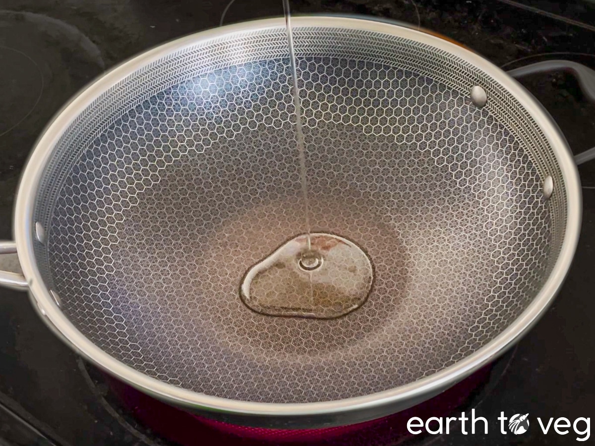 Oil is drizzled into a Hexclad wok.