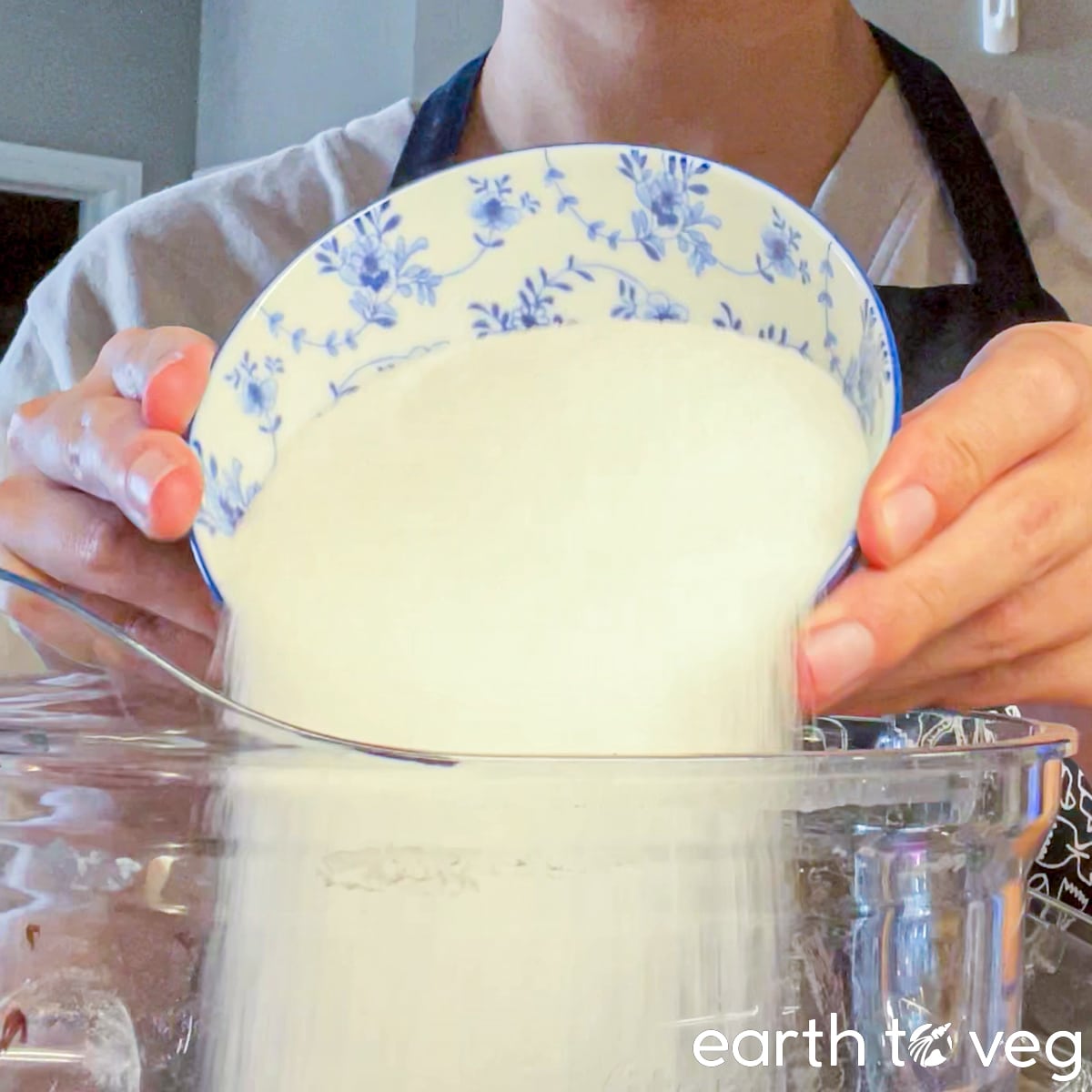 Sugar is poured into a large Vitamix blender jar.