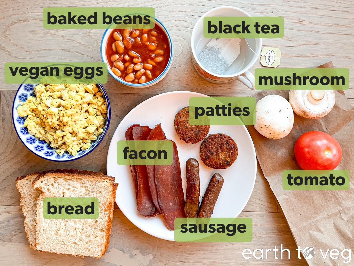 Ingredients for a vegan fry up are laid out on a wooden table.