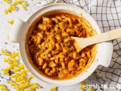 A pot full of Vegan Hamburger Helper being stirred with a wooden spoon.